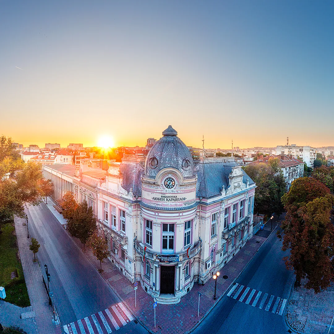 Aerial view of the Lyuben Karavelov Library in Ruse at sunrise, with the historic building, quiet streets and the first light over the city.