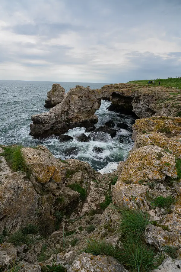 Natural stone arch and rugged limestone cliffs above the waves at Tyulenovo on Bulgaria’s northern Black Sea coast.