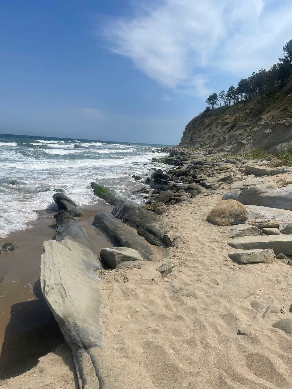 Rocky shoreline beside Chaika Beach, with waves breaking along the narrow passage towards Smrikite South Beach.