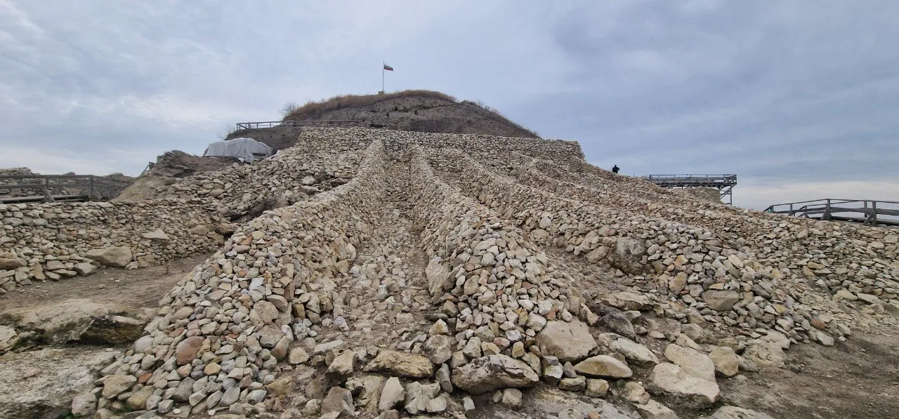 Archaeological remains and stone structures at Provadia-Solnitsata, with excavation areas rising towards the top of the prehistoric settlement.