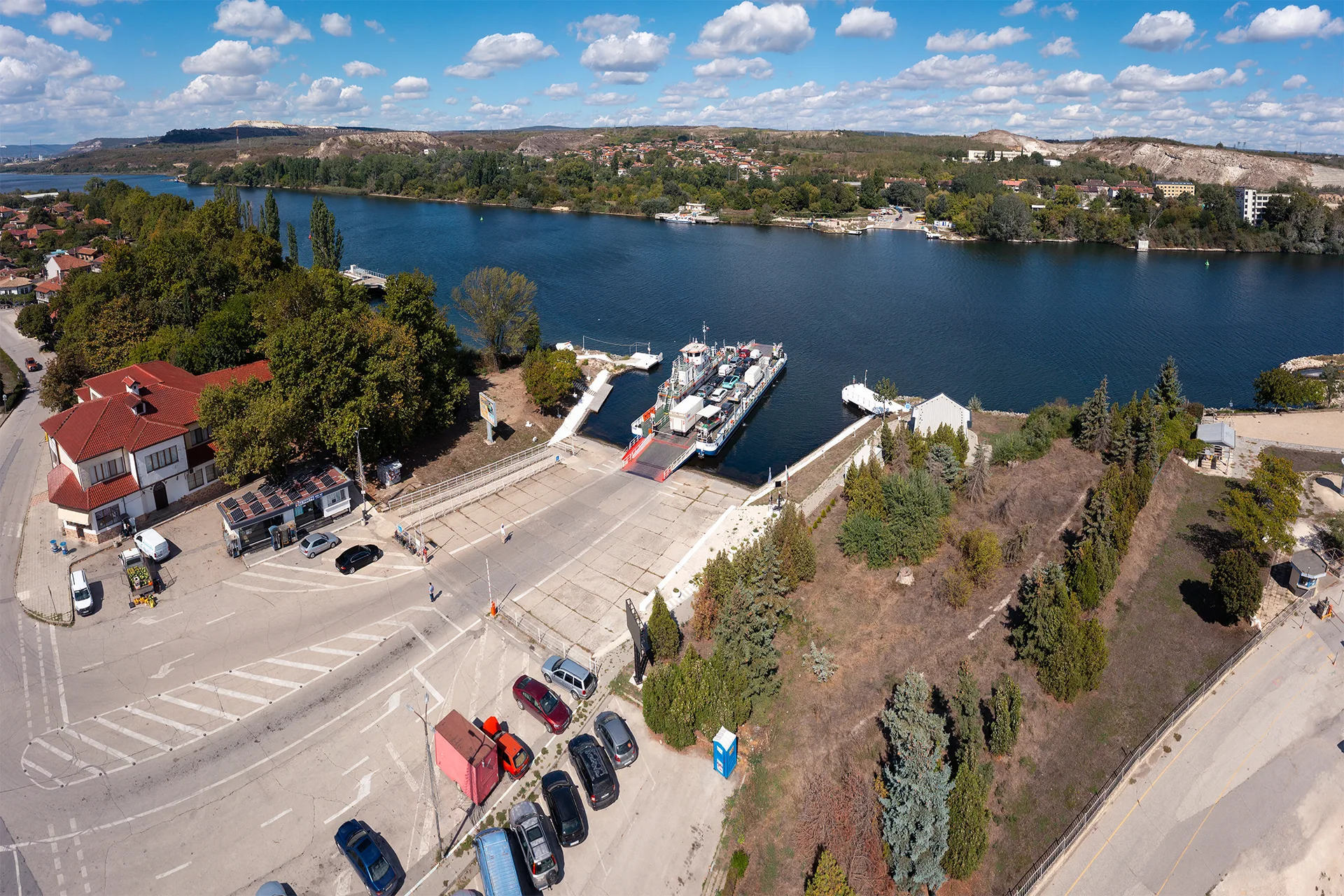 Aerial view of the Beloslav ferry crossing the canal with cars and other vehicles on board, connecting the two sides of the town.