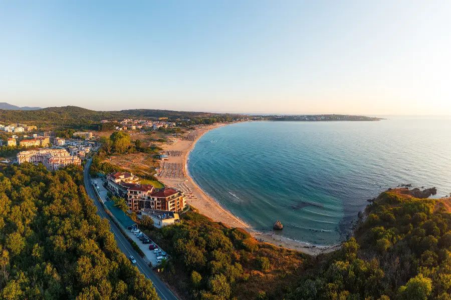Aerial view of Smokinya and Kavatsi Bay near Sozopol at sunrise, with the curved beach, calm sea and coastal buildings in warm morning light.