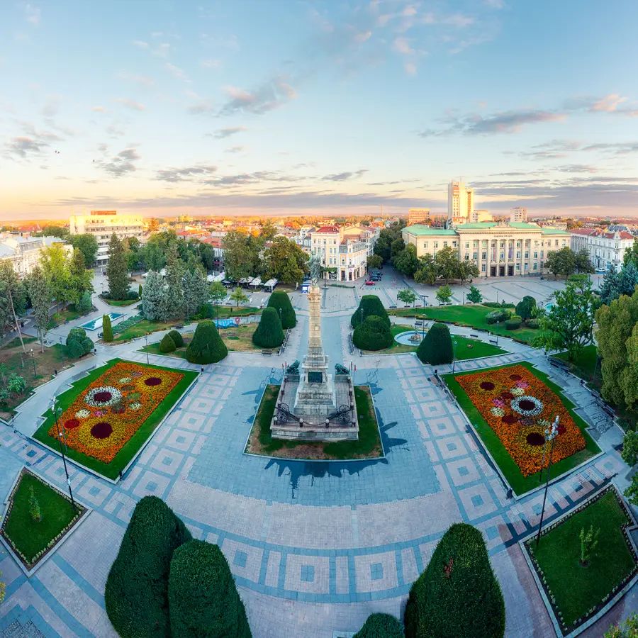 Aerial morning view of Freedom Square in Ruse with the Monument of Freedom, geometric gardens and historic buildings around the city centre.